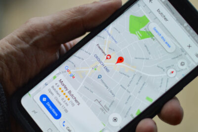 in der Hand gehaltenes Smartphone mit einem lokalen Suchergebnis